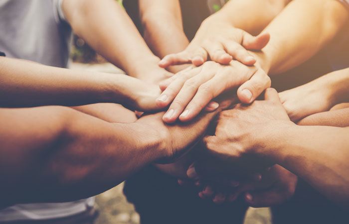 Friends stacking hands together